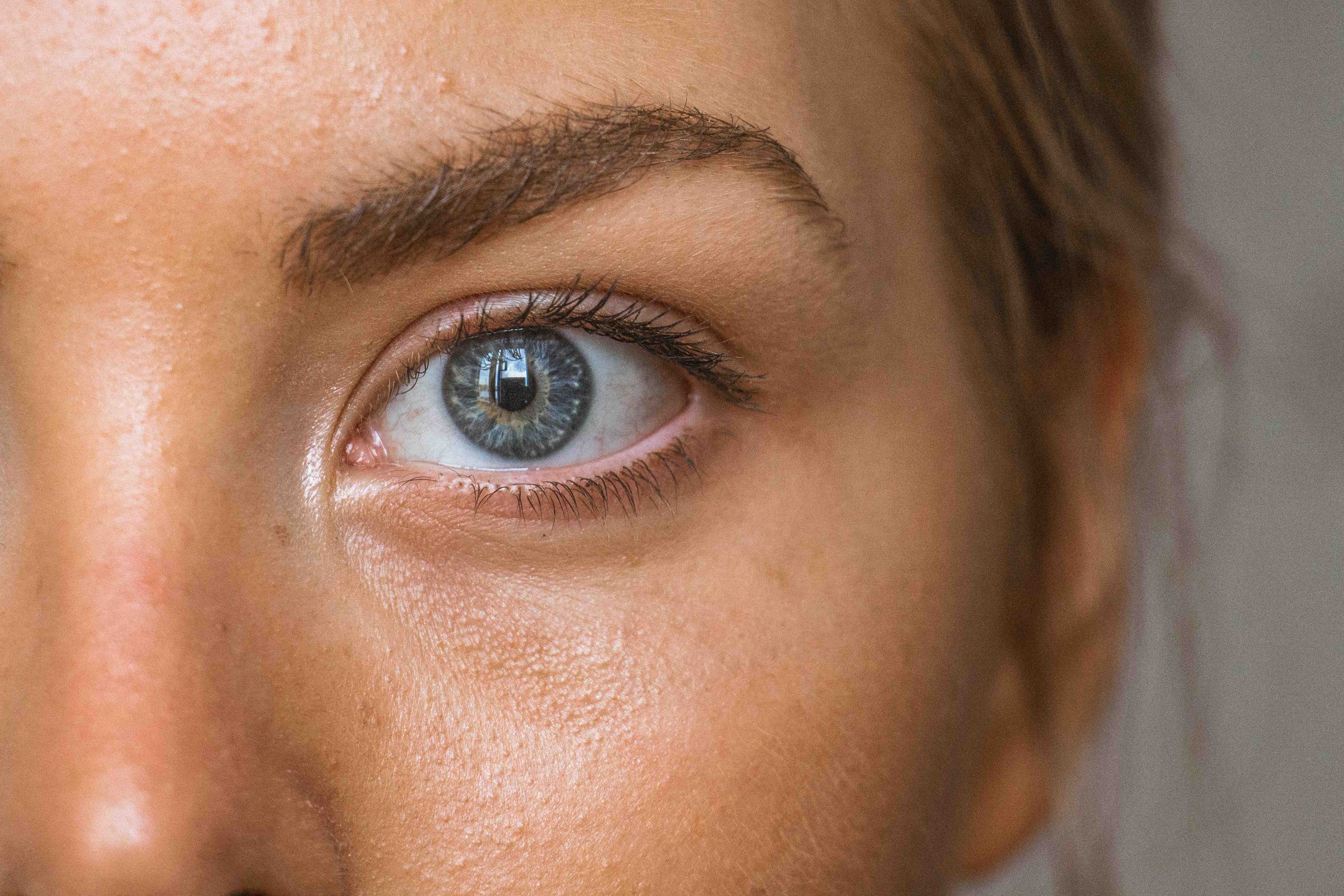 Close-up of a person's eye showing detailed skin texture and natural beauty